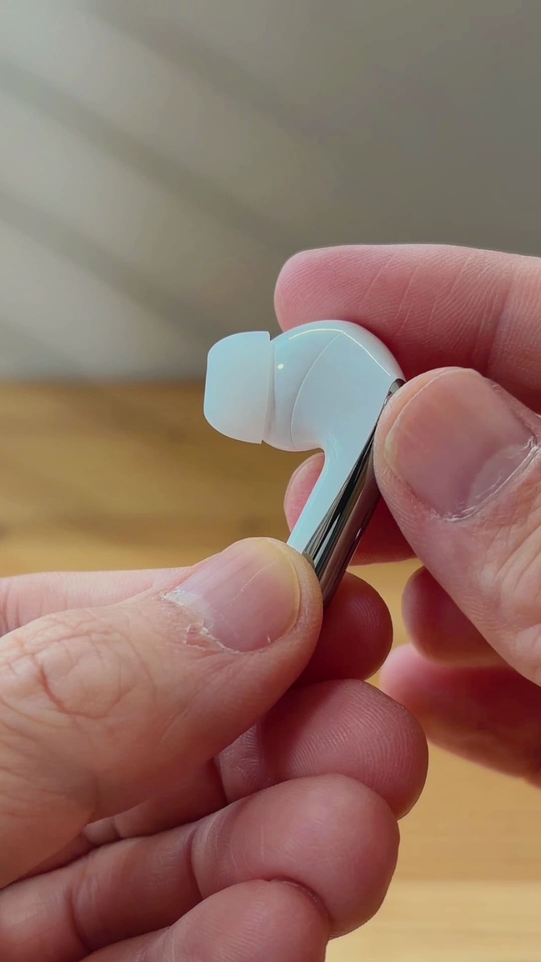 QCY MeloBuds N60のイヤホン片側を指でつまんだところ。イヤーピース付きのスティック型