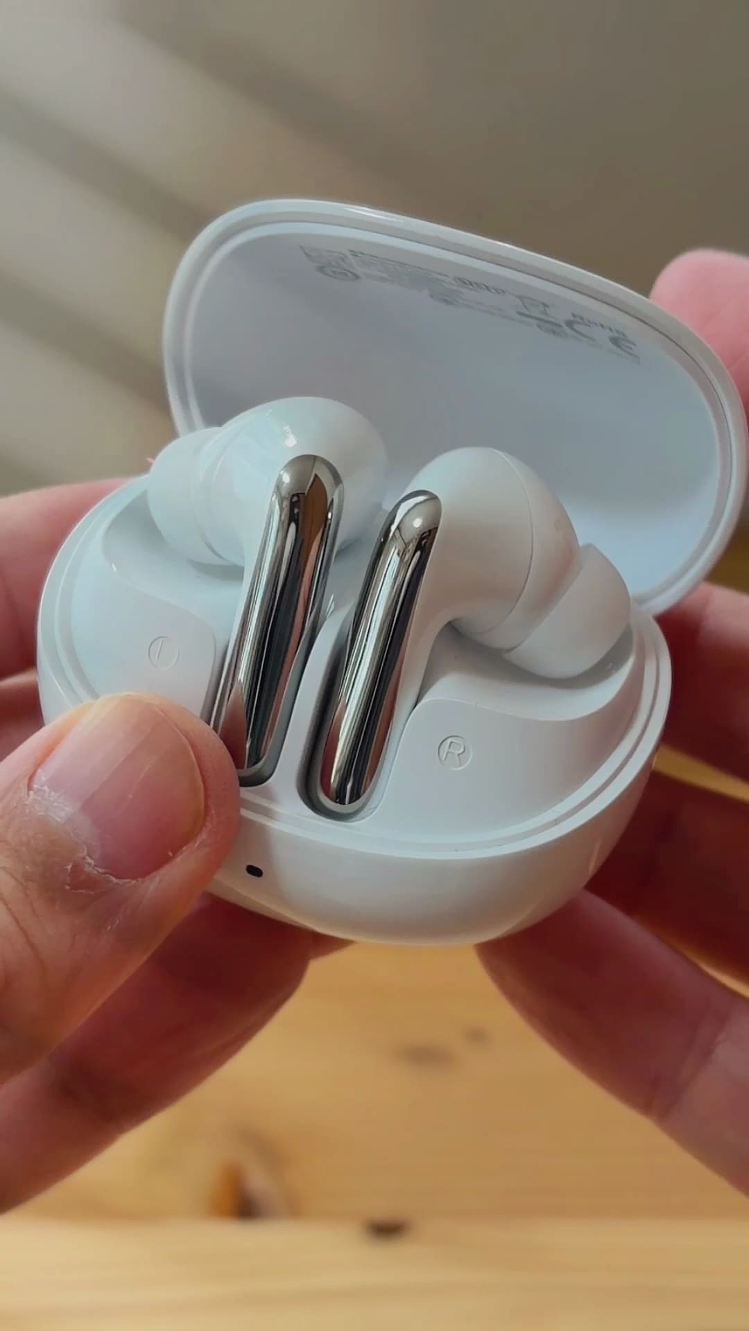 QCY MeloBuds N60の充電ケースを開けたところ。イヤホンのステム部分は光沢のあるシルバー