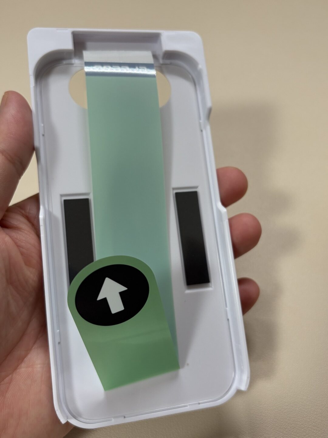 エレコム PM-A26CFLGGT の貼り付けツールの内側。フィルムがセットされ、ホコリ取りシールが付いている