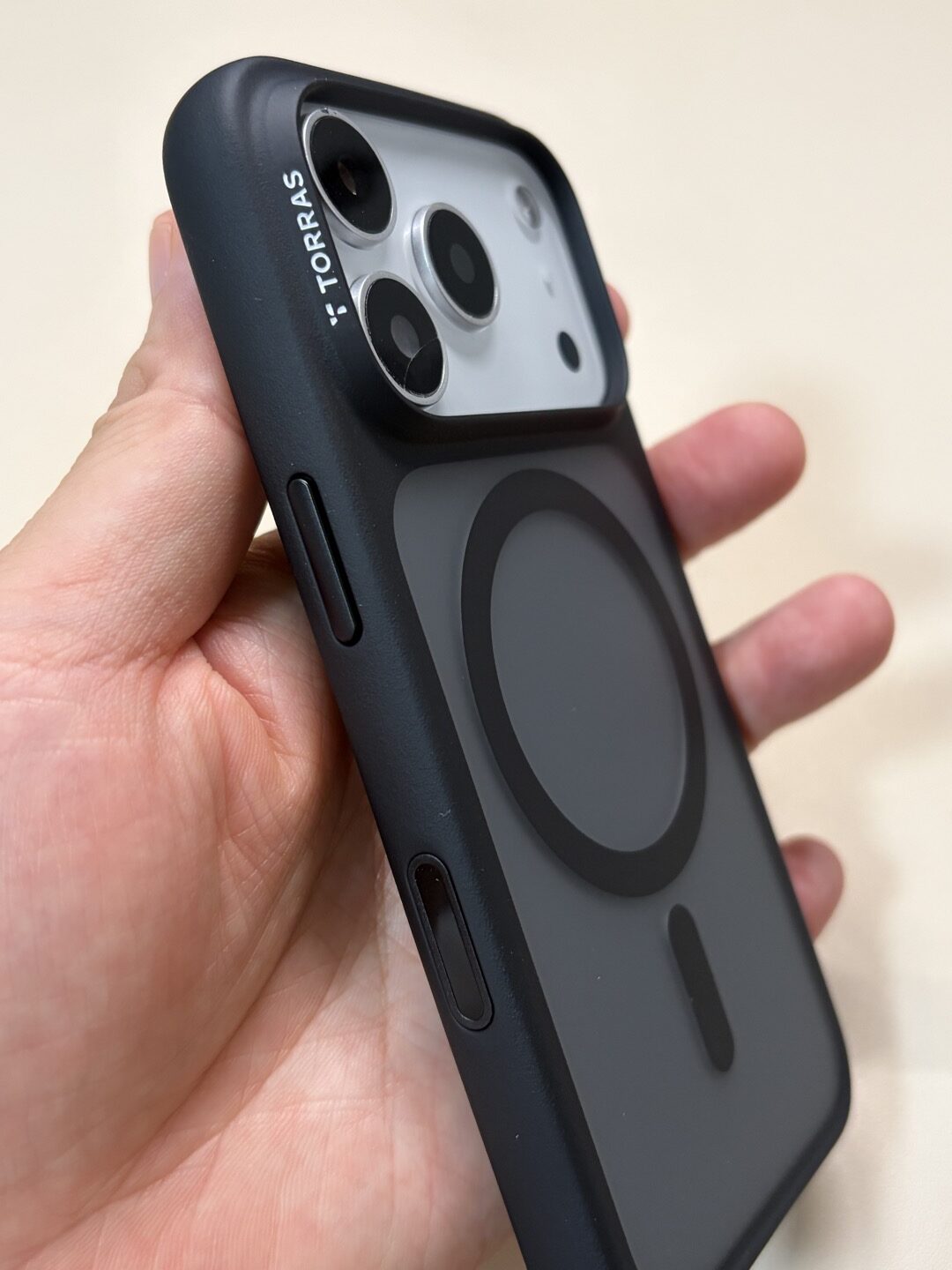 iPhone 17 ProモックにTORRAS Guardian-Mag 黒（iPhone 18 Pro用）を装着し、手に持って斜めから見た背面