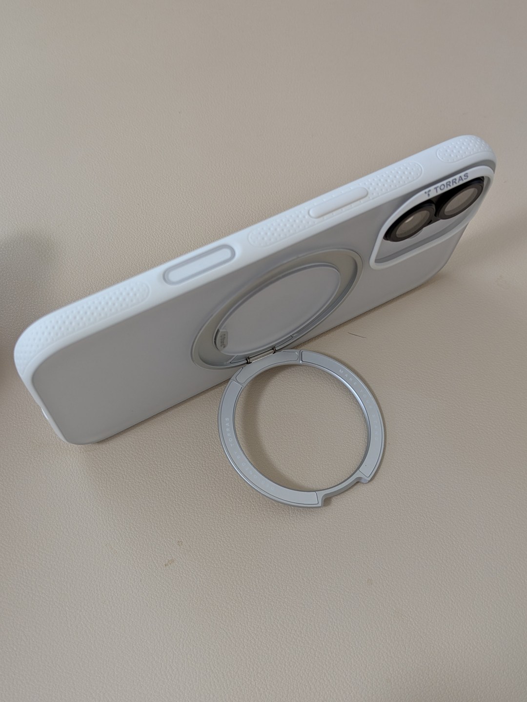 iPhone 17にTORRAS Ostand白を装着しリングスタンドで立てたところ